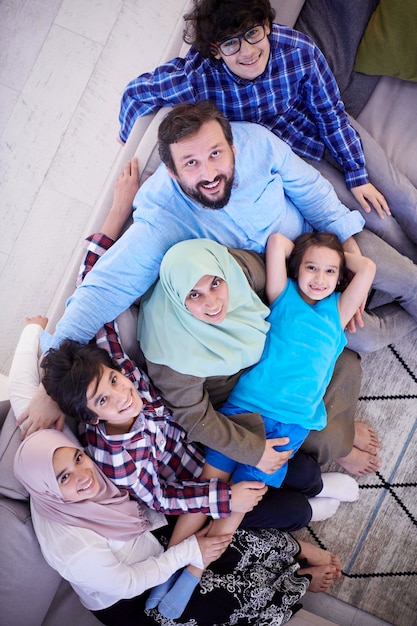 Moslim familieportret met arabische tienerkinderen bij modern interieur bovenaanzicht