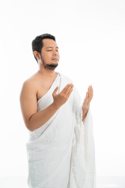 Moslim man bidden in witte traditionele kleding