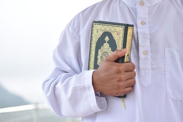 Moslim man die heilige koran leest. islamitisch concept