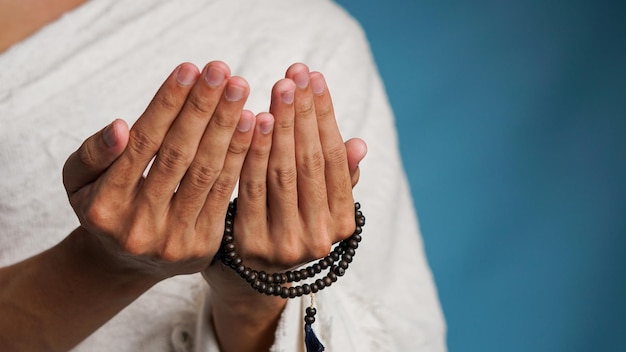 Foto moslim man in ihram kleding bidt met gebedskralen in zijn handen