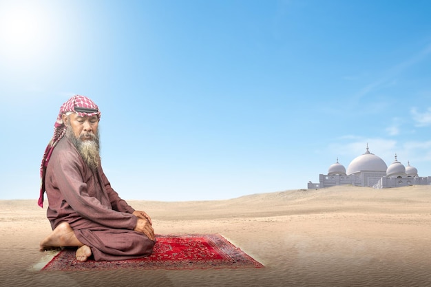 Moslim man met een baard die keffiyeh draagt met agal in biddende positie salat op het gebedskleed