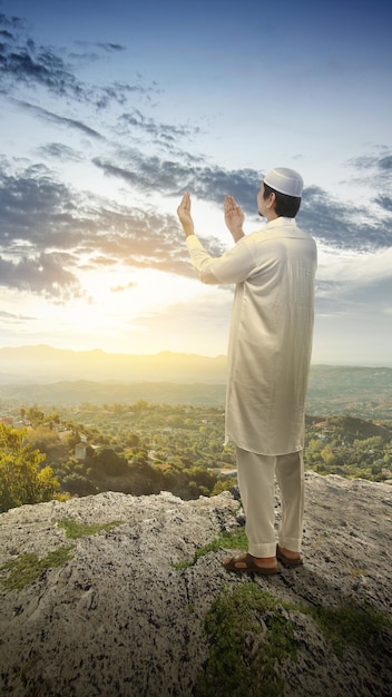 Moslim man staat terwijl hij zijn handen opsteekt en bidt