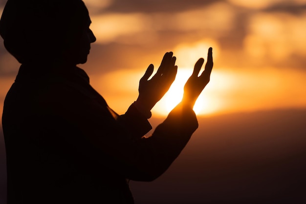 Moslim vrouw gebed bidden met de handen open doen dua bij zonsondergang aanbidden allah
