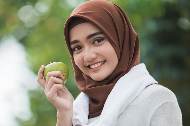 Moslim vrouwelijke sport die een appel eet