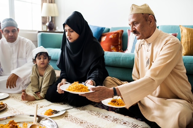 Moslimfamilie die diner op de vloer hebben