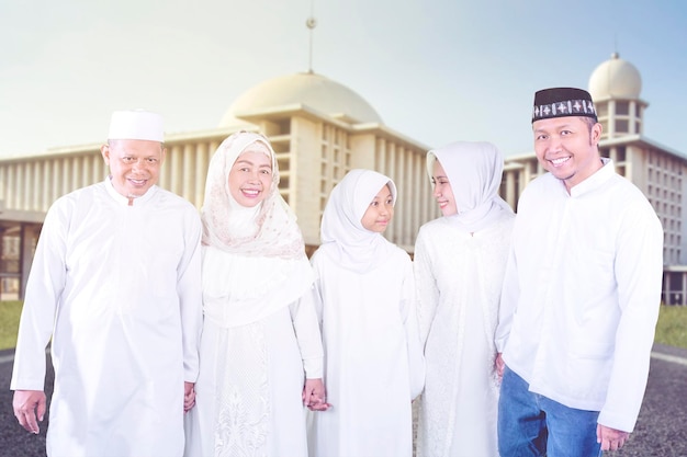 Moslimfamilie van drie generaties die naar de camera glimlacht
