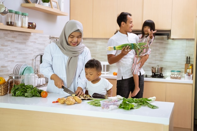 Moslimgezin met twee kinderen die samen thuis koken en zich voorbereiden op het diner en vasten tijdens de iftarpauze