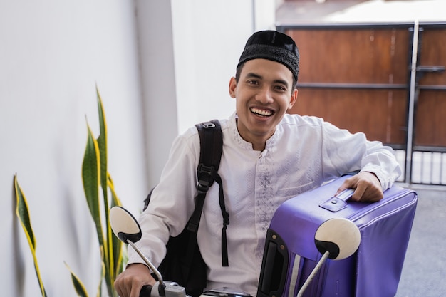 Moslimman berijdt motorfiets voor idul fitri balik kampung mudik die koffer dragen