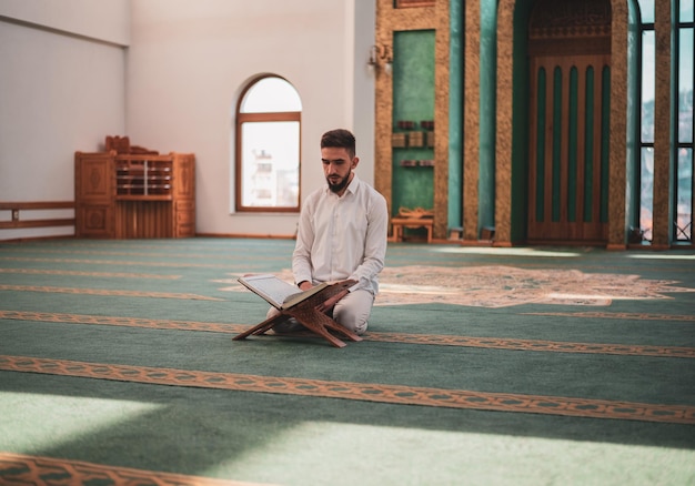 Foto moslimman die in de moskee bidt en de koran leest