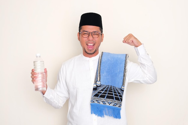 Moslimman toont zijn biceps spier terwijl hij een plastic fles vasthoudt