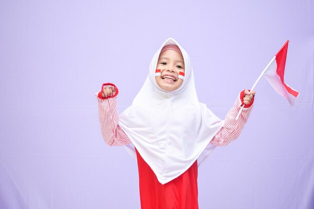 moslimmeisje viert de indonesische onafhankelijkheidsdag op 17 augustus als uitdrukking van het winnen van de race