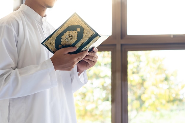 Moslimmens die heilige Koran lezen Heilige Koran in Hand met Arabische tekstbetekenis van Al Quran Islamitische conceptenachtergrond