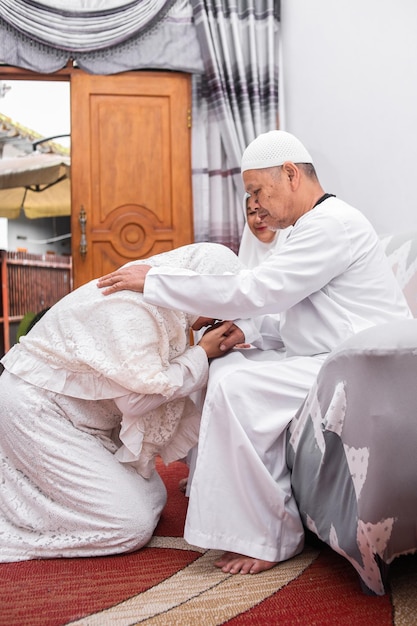 Moslimvrouw kust de hand van zijn vader om zich te verontschuldigen bij het vieren van Eid Mubarak Ramadan.