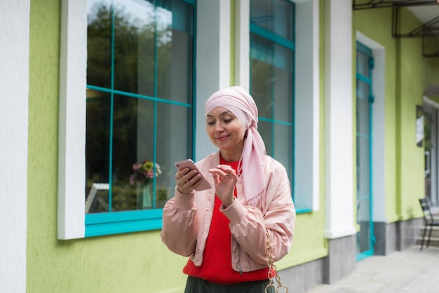 Moslimvrouw maakt buiten een videogesprek via de mobiele telefoon