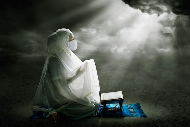 Moslimvrouw met gezichtsmasker biddend tot Allah