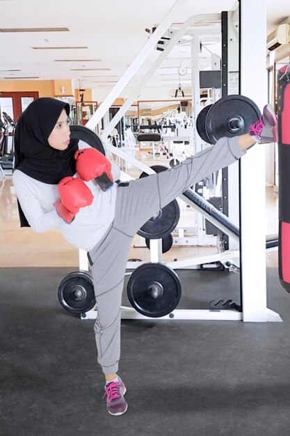 Moslimvrouw oefent kickboxen in een sportschool