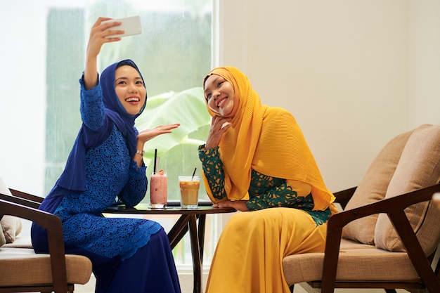 Moslimvrouwen fotograferen in café