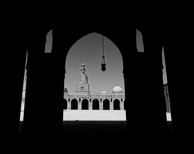 Photo mosque of ibn tulun seen through archway