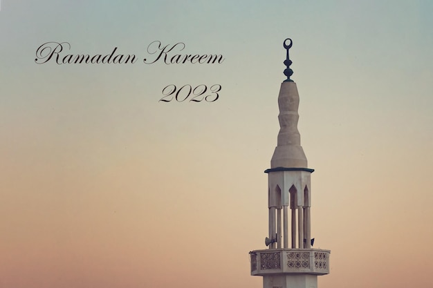 Mosque Minaret against sunset sky Ramadan Kareem Greetings