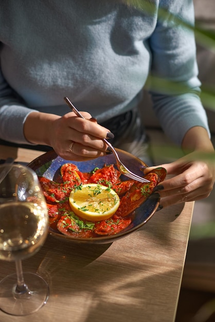 Mosselen in tomatensaus vrouwelijke handen houden mosselen vast