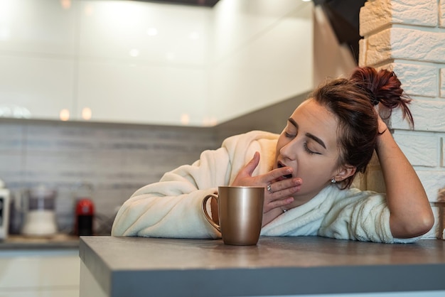 La donna più bella si sveglia molto presto e prepara il caffè più delizioso e lo assaggia concetto di caffè mattutino