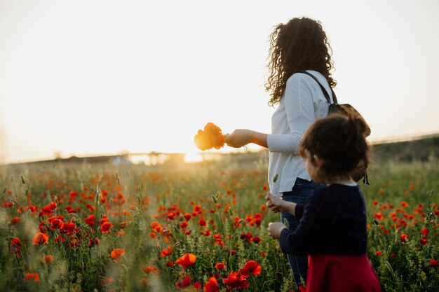 Photo mother aand daughter on poppy field