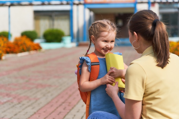 母親は子供を学校に連れて行く。