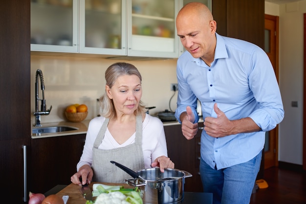 Mother and adult son preparing meal together