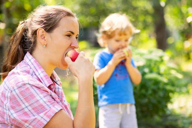 写真 公園でリンゴを食べている母と子