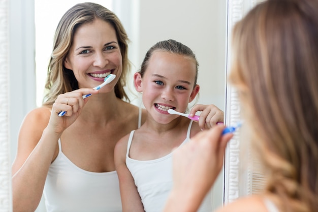 Фото Мать и дочь чистят зубы в ванной комнате