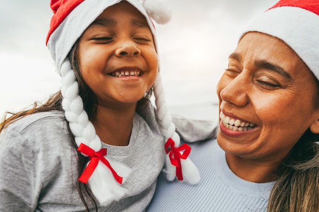 写真 サンタクロースの帽子をかぶってクリスマスの時期に楽しむ母と娘 家族と休日のコンセプト