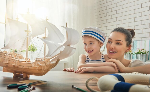 Фото Мать и ее ребенок делают модель корабля мечты о морских приключениях и путешествиях