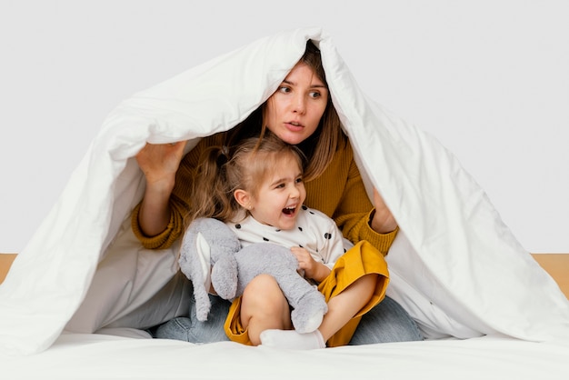 写真 毛布の下に隠れている母と子