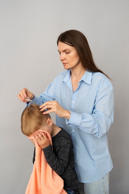 Photo mother applying lice treatment side view