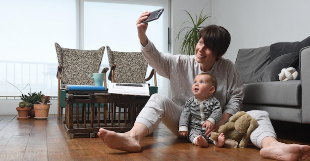 Mother and baby are at home and take a selfie