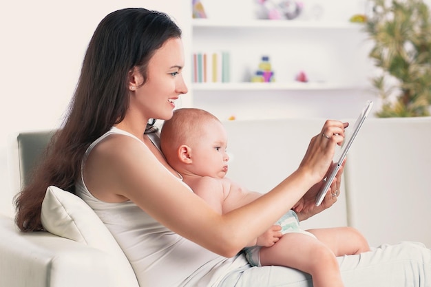 Foto madre e bambino stanno cercando di giocare e leggere il computer tablet