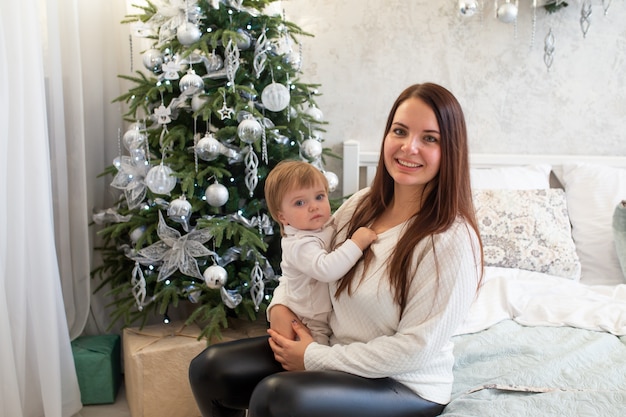 Mother and baby on bed at home on Christmas holidays