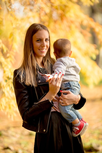 Mother and baby boy in autumn park