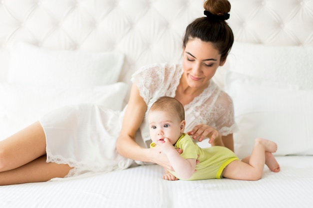 Mother and baby girl on the bed