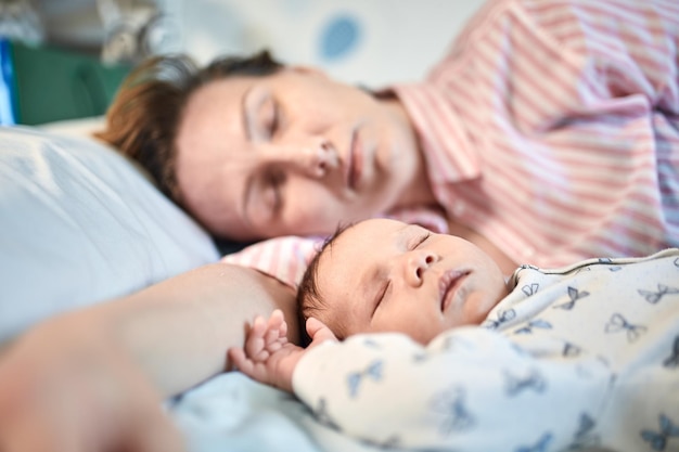 Mother and baby lying on bed