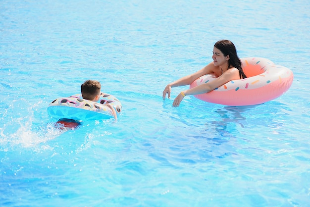 Madre e bambino nella piscina all'aperto del resort tropicale. mamma e bambino che giocano in acqua.