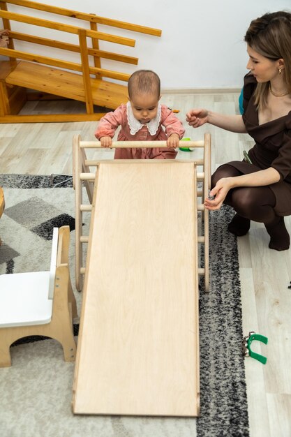 A mother and baby play with a table