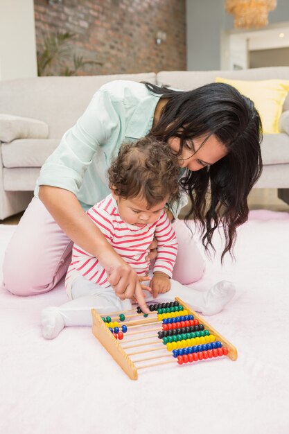 Mother and baby playing with abacus in living room