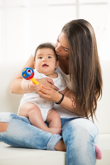 Mother and baby sitting and playing at home