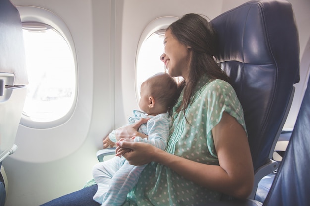 母親と赤ちゃんが飛行機の中で一緒に座っています。