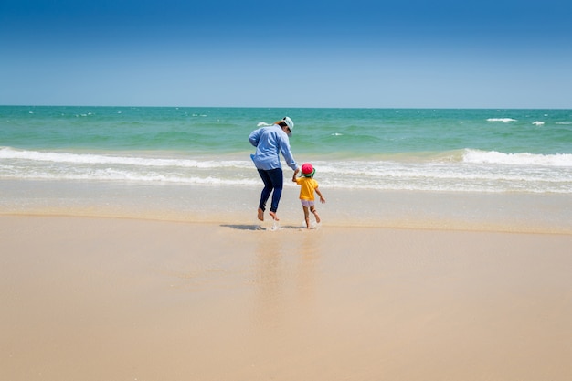 Mother and baby walking to sea