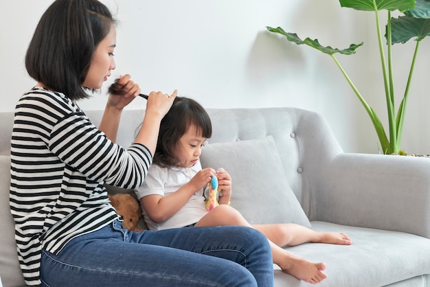 Madre che intreccia i capelli di sua figlia