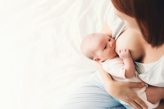 Фото Мать кормит ребенка грудью на руках дома красивая мама кормит грудью своего новорожденного ребенка