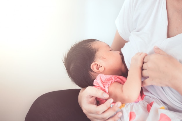 Mother breastfeeding her newborn baby girl. 