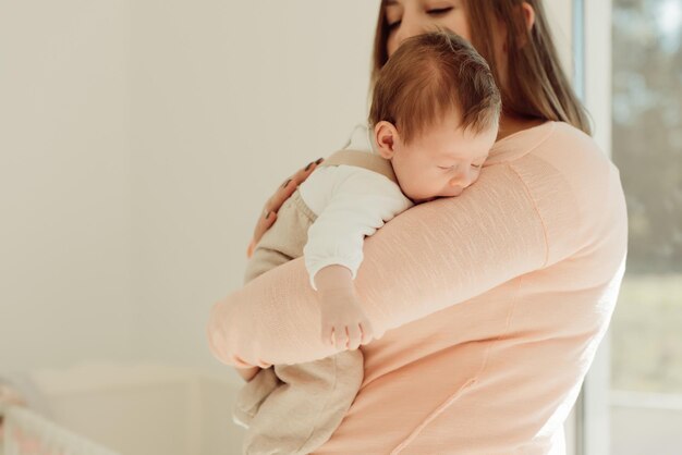 写真 母が可愛い娘を抱いて家にいる